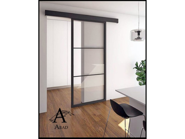 Puerta corredera de hierro lacada en negro de una sola hoja.